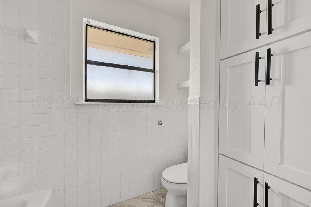 8027 Simpson Drive Amarillo, TX 79121 - Photo 20 of 32 a bathroom with a toilet sink