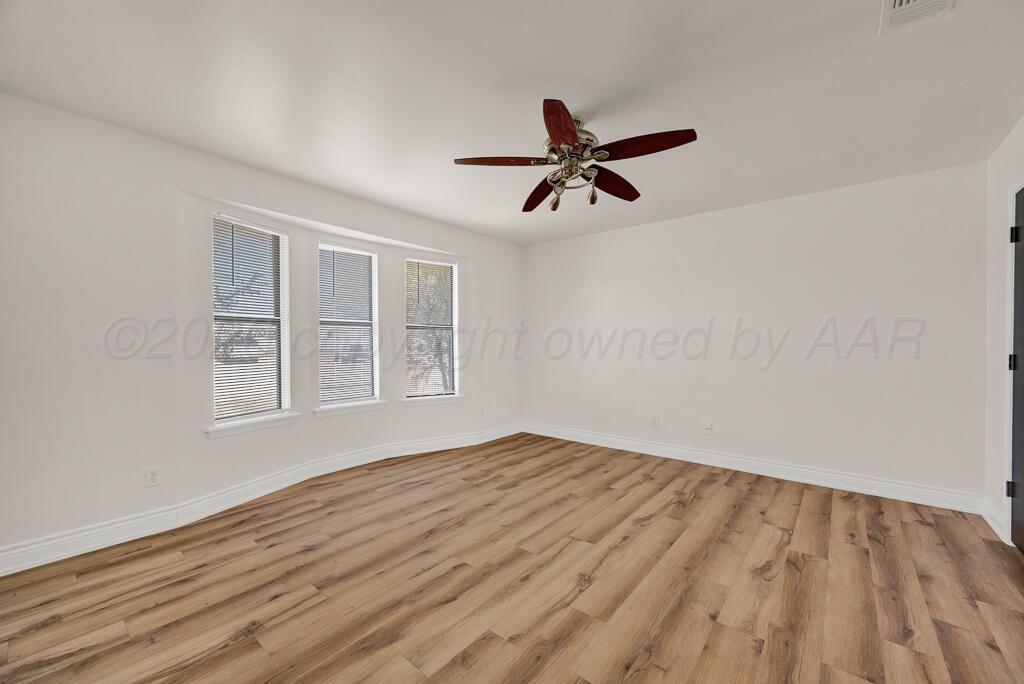 8027 Simpson Drive Amarillo, TX 79121 - Photo 23 of 32 a view of empty room with wooden floor and fan