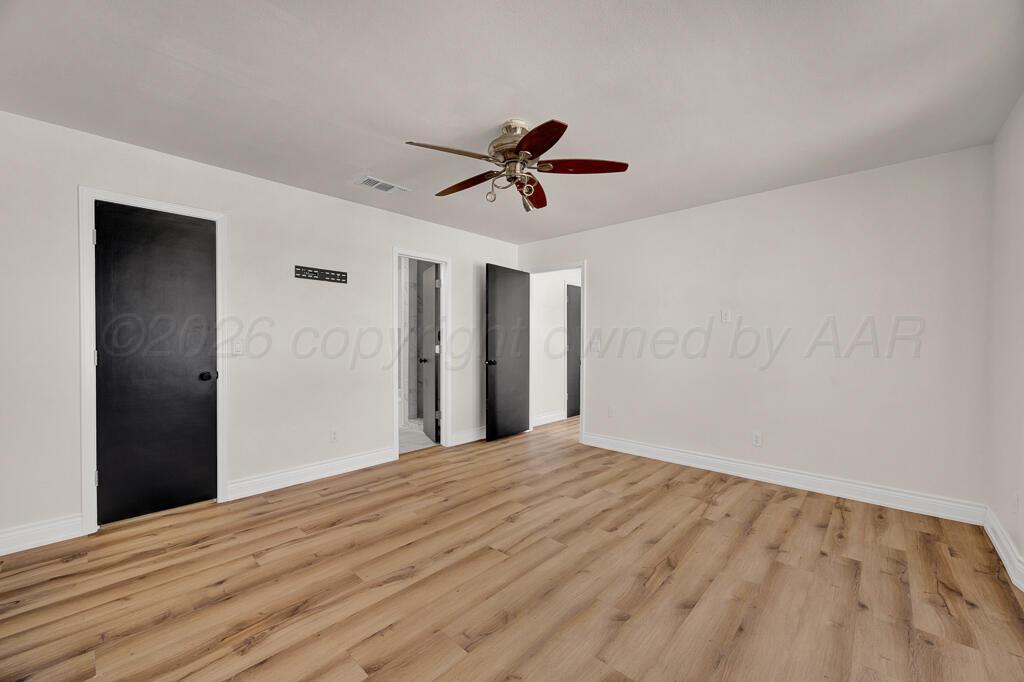 8027 Simpson Drive Amarillo, TX 79121 - Photo 24 of 32 a view of a big room with wooden floor and a ceiling fan