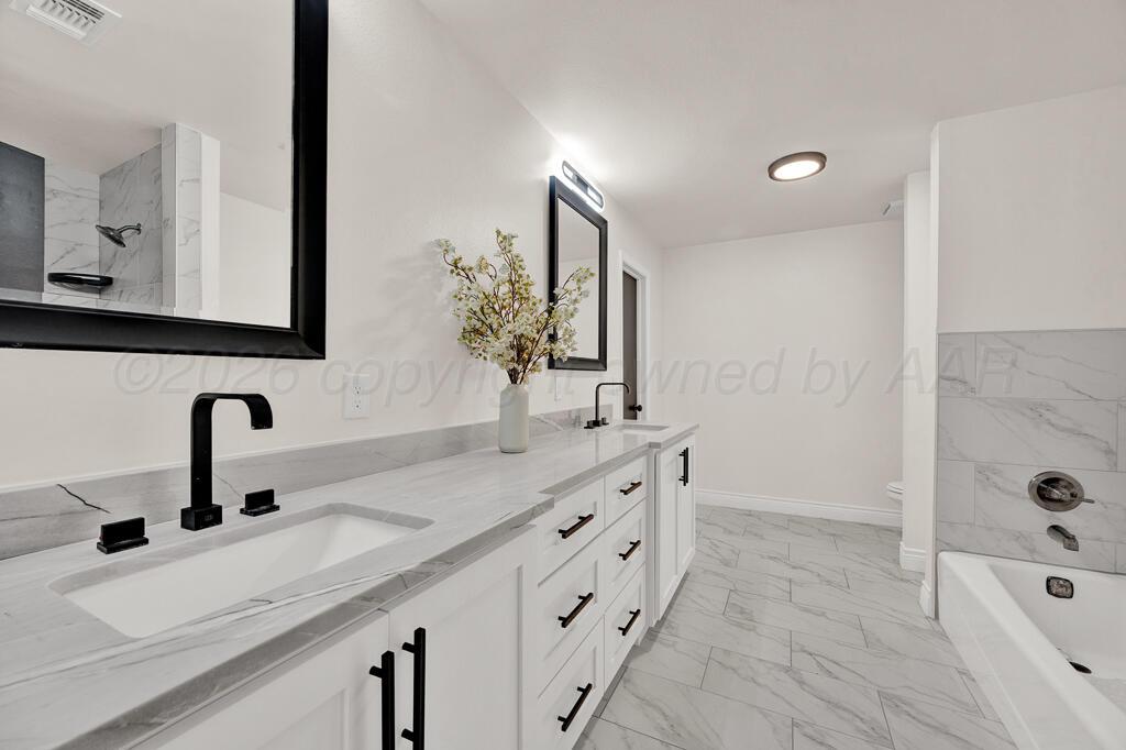8027 Simpson Drive Amarillo, TX 79121 - Photo 26 of 32 a bathroom with a tub sink and mirror