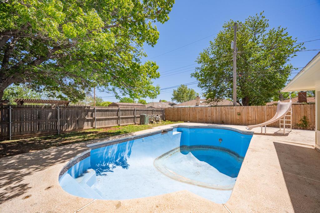 8027 Simpson Drive Amarillo, TX 79121 - Photo 30 of 32 a view of a swimming pool with a patio and wooden fence