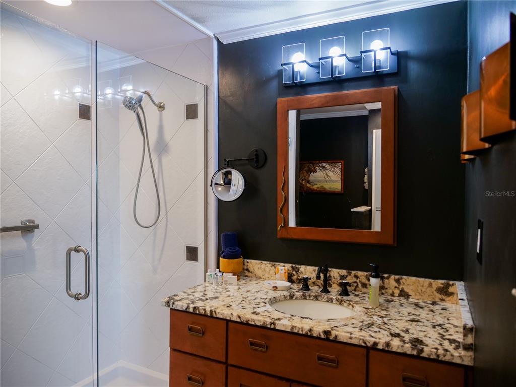 1711 County Road 13 South Elkton, FL 32033 - Photo 64 of 78 a bathroom with a granite countertop sink shower and a mirror