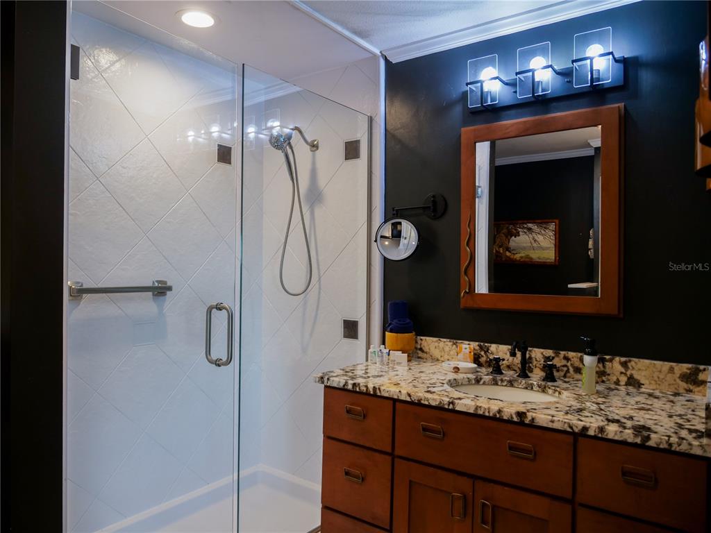 1711 County Road 13 South Elkton, FL 32033 - Photo 65 of 78 a bathroom with a granite countertop sink a shower and a mirror