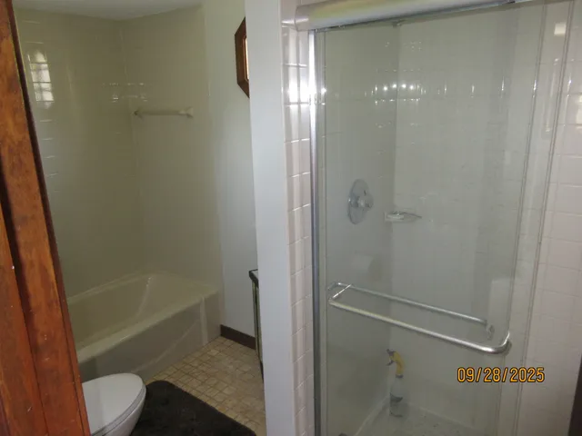 a bathroom with a shower a toilet and sink