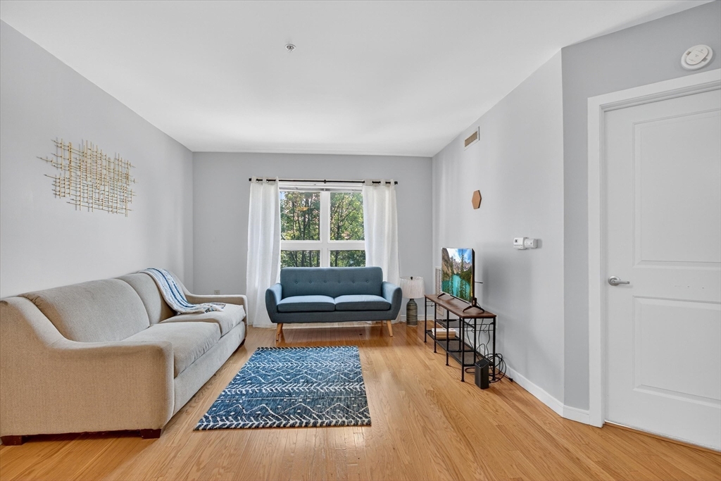 175 Cottage Street, Unit 312 Chelsea, MA 02150 - Photo 5 of 13 a living room with furniture and a window