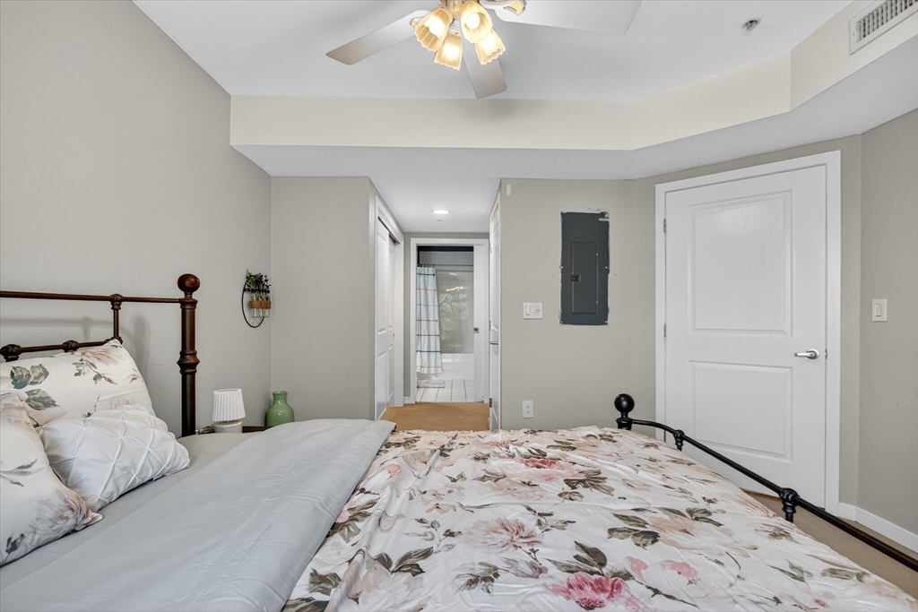 175 Cottage Street, Unit 312 Chelsea, MA 02150 - Photo 9 of 13 a bedroom with a bed and a chandelier