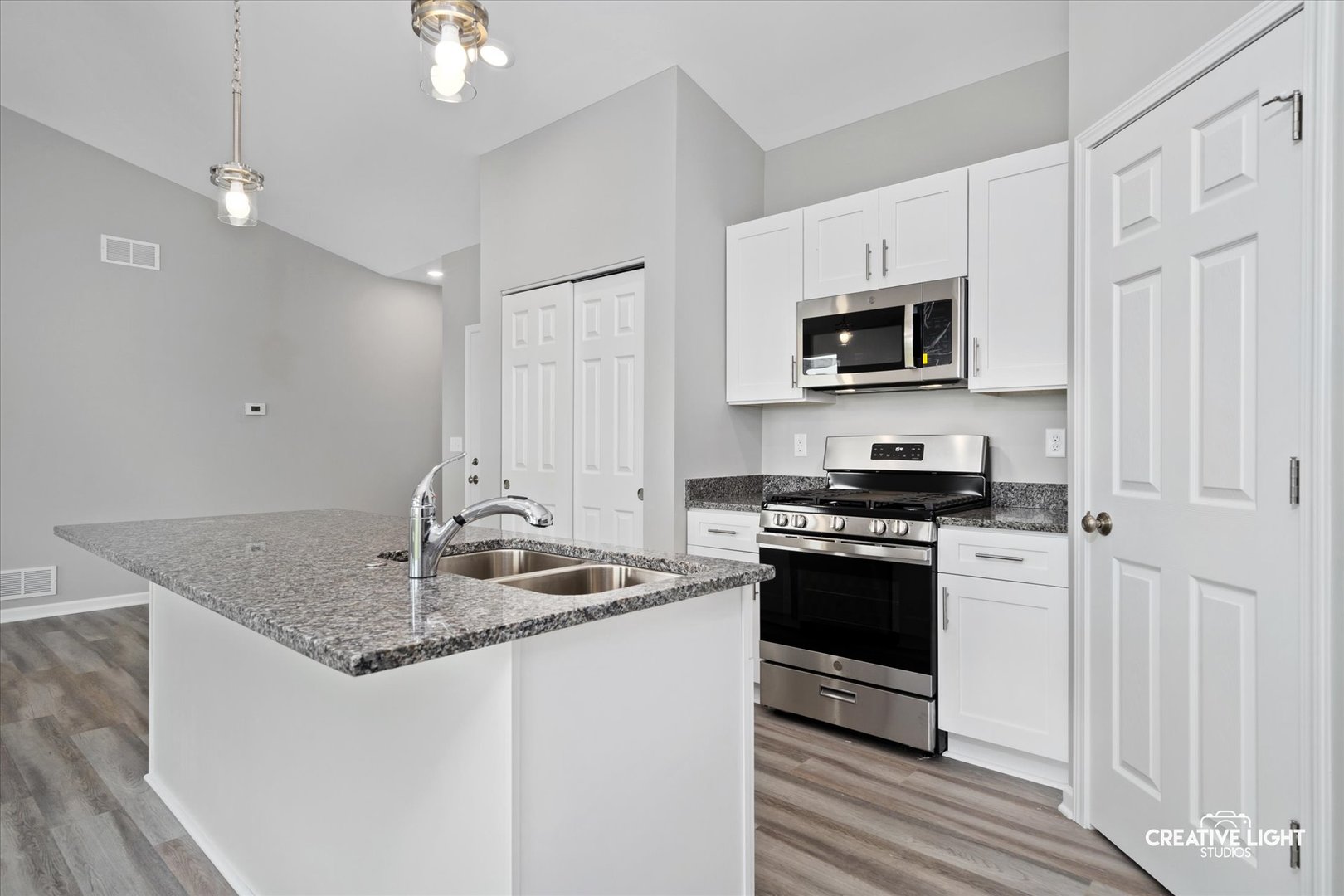 526 Hahn Drive Cortland, IL 60112 - Photo 4 of 20 a kitchen with stainless steel appliances granite countertop a sink stove and microwave