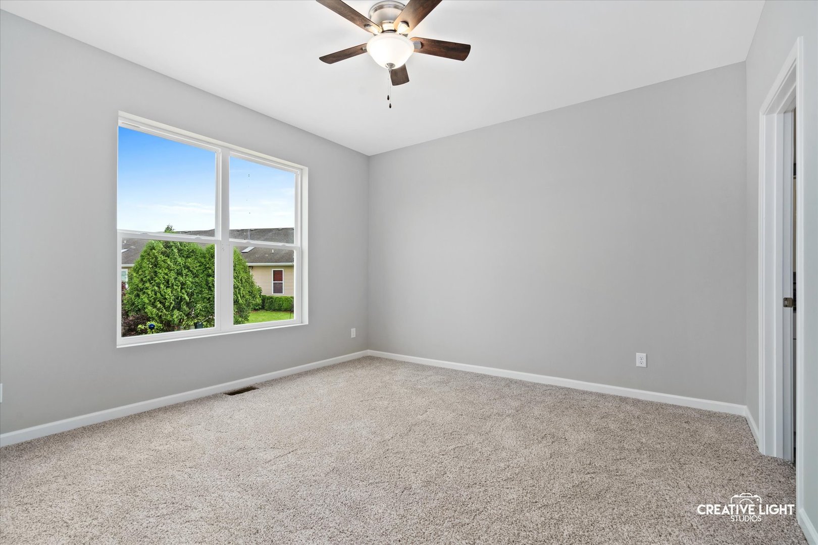 526 Hahn Drive Cortland, IL 60112 - Photo 9 of 20 an empty room with windows and ceiling fan