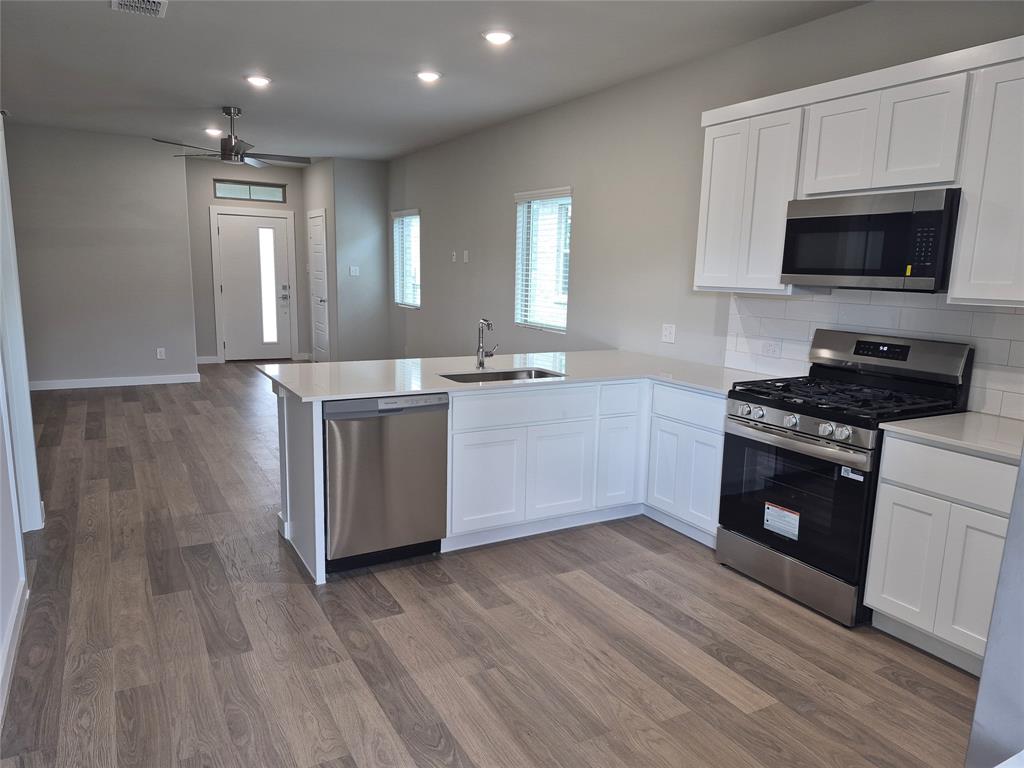 872 Sunflower Road Lavon, TX 75166 - Photo 3 of 12 a kitchen with stainless steel appliances a stove a sink and a microwave