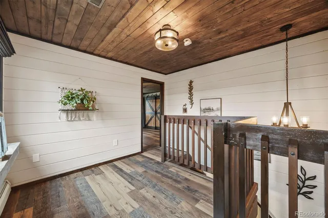 a spacious bedroom with a bed and wooden floor