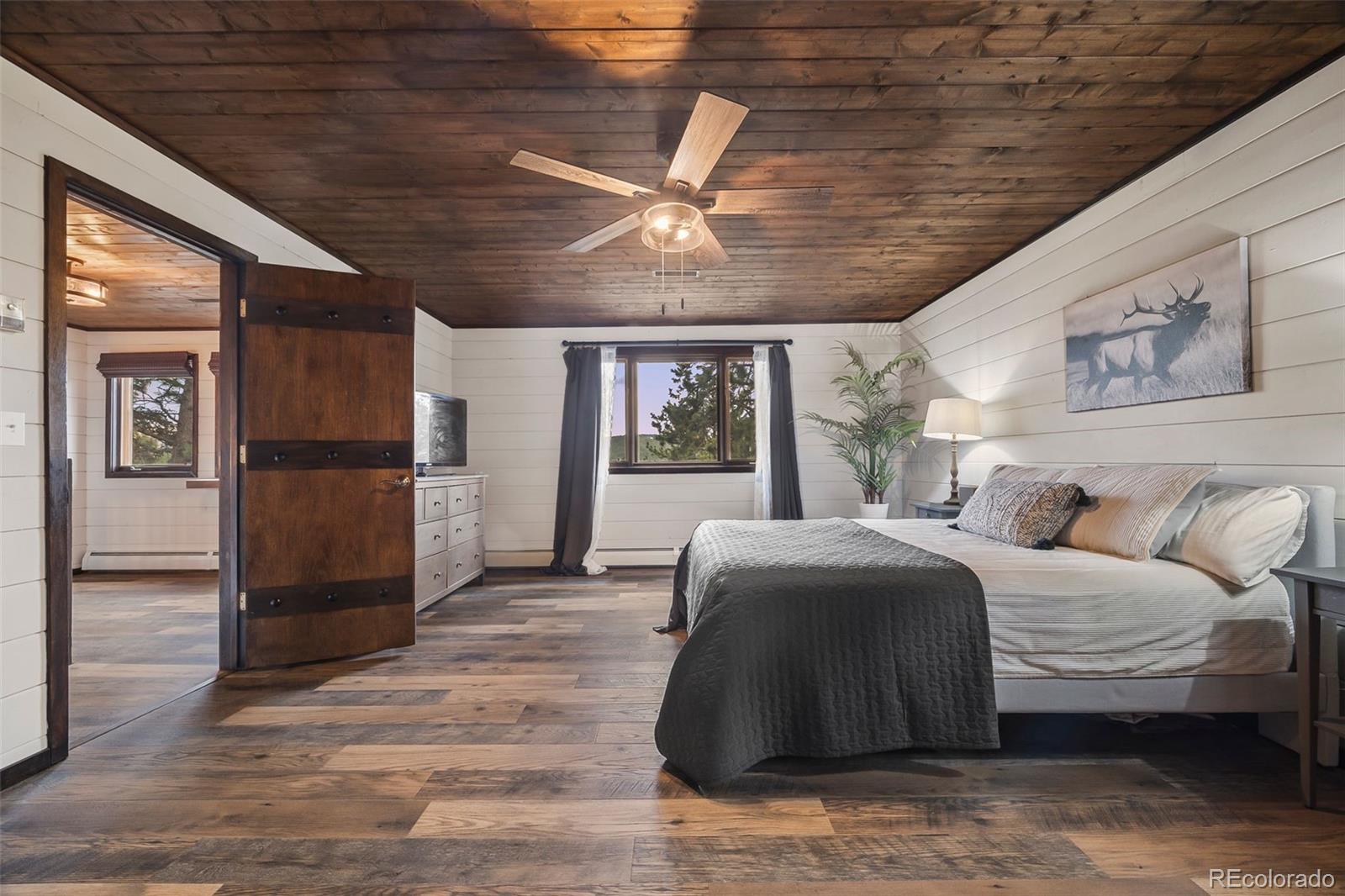 193 Mary Beth Road Evergreen, CO 80439 - Photo 18 of 46 a spacious bedroom with a bed and a large window