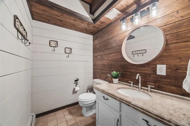 a bathroom with a granite countertop sink toilet a mirror and shower