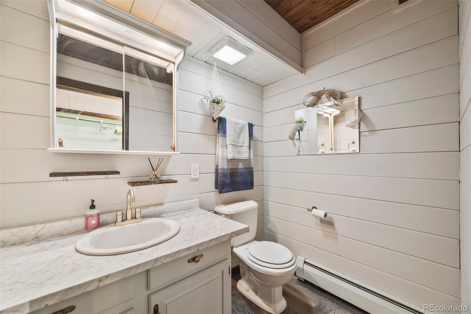 193 Mary Beth Road Evergreen, CO 80439 - Photo 26 of 46 a bathroom with a granite countertop sink toilet a mirror and shower