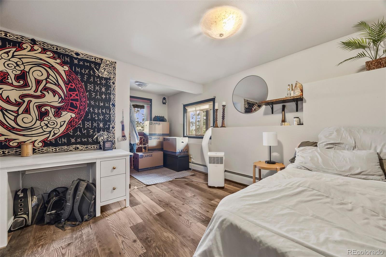 193 Mary Beth Road Evergreen, CO 80439 - Photo 33 of 46 a bedroom with bed and a chandelier