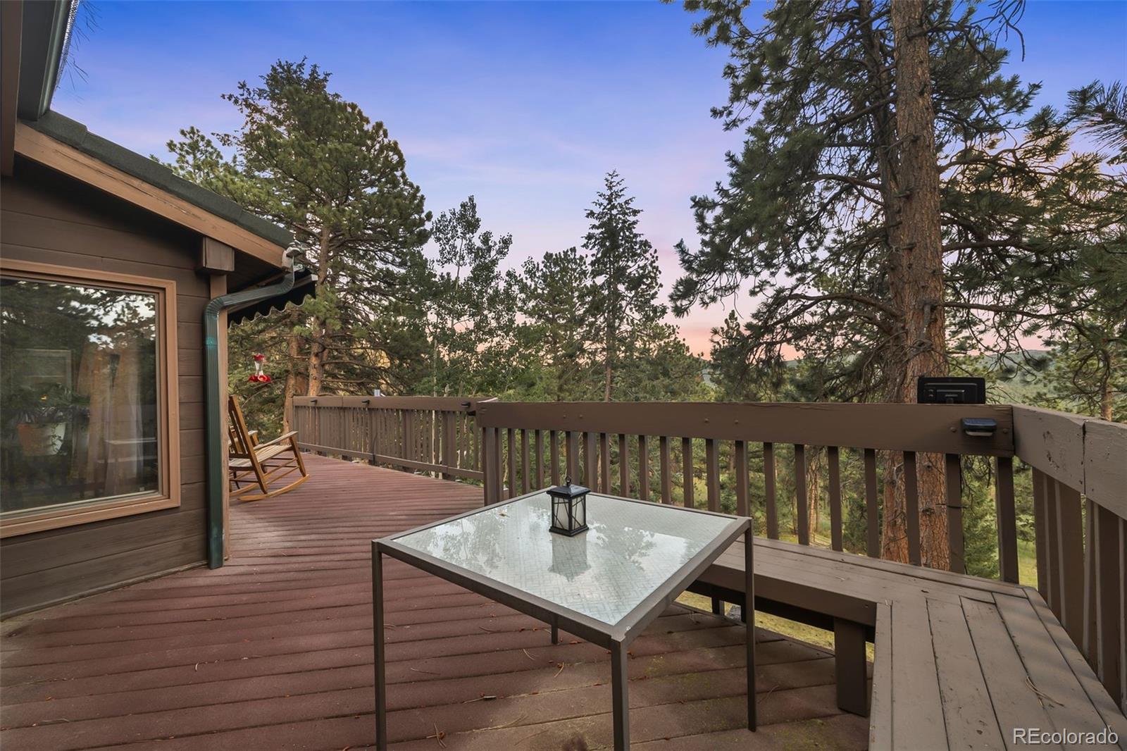 193 Mary Beth Road Evergreen, CO 80439 - Photo 38 of 46 a balcony with wooden floor table and chairs