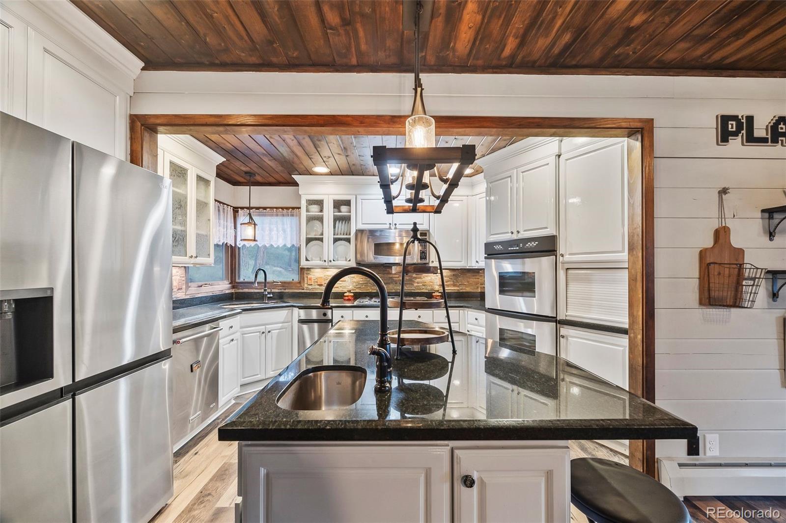 193 Mary Beth Road Evergreen, CO 80439 - Photo 8 of 46 a kitchen with a refrigerator a sink and cabinets