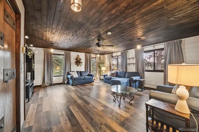 a living room with furniture floor to ceiling window and wooden floor