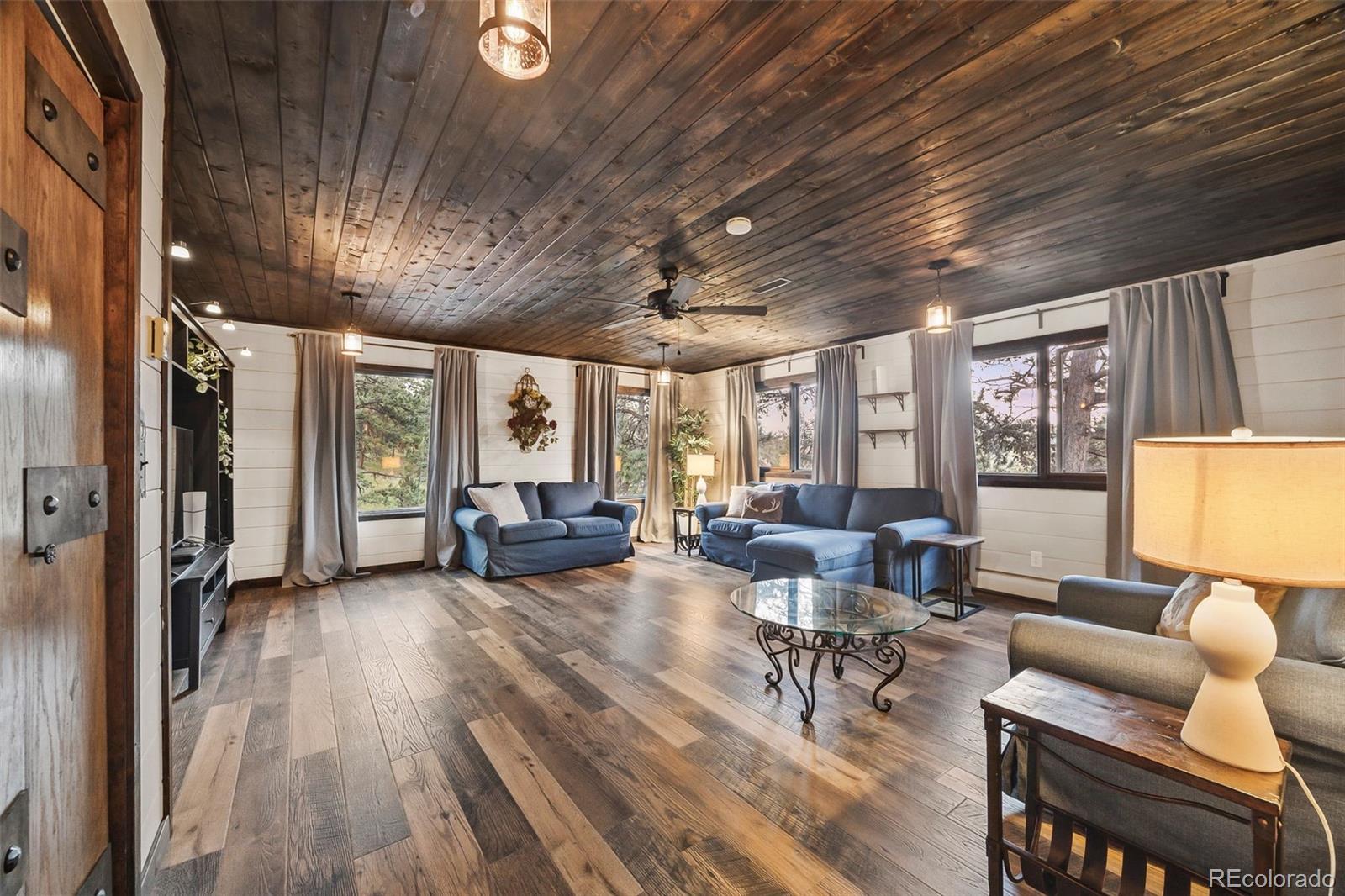 193 Mary Beth Road Evergreen, CO 80439 - Photo 9 of 46 a living room with furniture floor to ceiling window and wooden floor