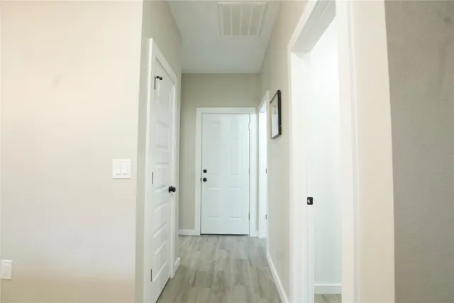 a view of a hallway with wooden floor