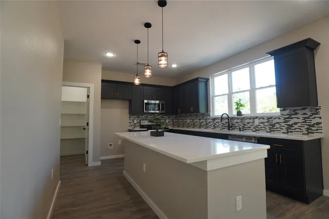 a kitchen with a sink a stove a refrigerator and a window