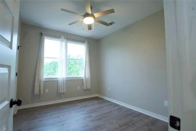 an empty room with a window and a fan
