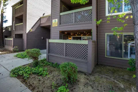 a view of a house with a small yard and wooden fence