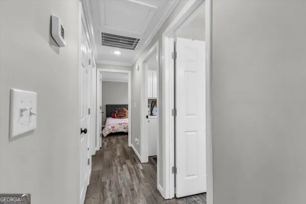 a view of a hallway with wooden floor and staircase