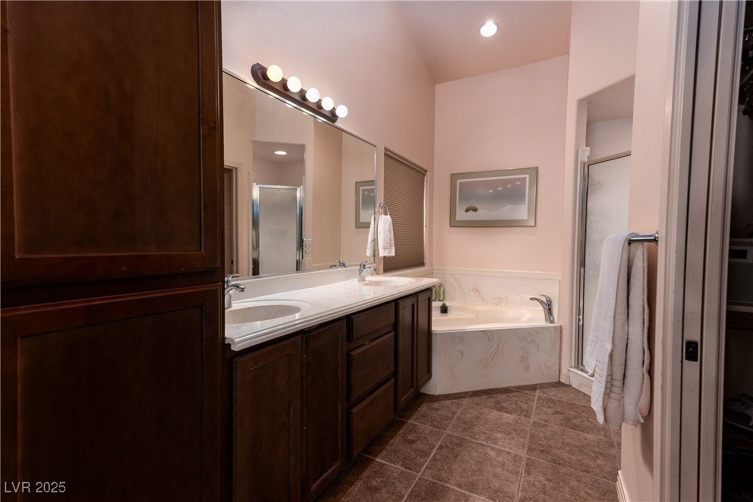 844 Sagedell Road Mesquite, NV 89027 - Photo 11 of 19 Full bathroom with a shower stall, double vanity, a bath, dark tile patterned flooring, and a closet