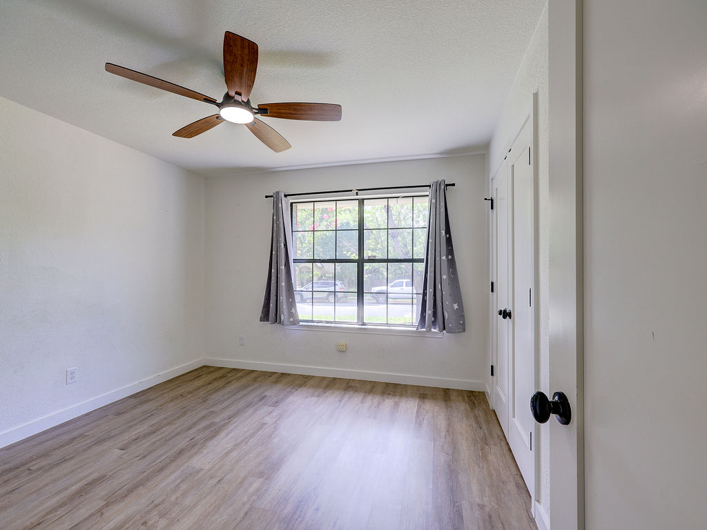 5842 Secrest Drive Austin, TX 78759 - Photo 40 of 40 A comfortable bedroom features light wood-look flooring and a window with natural illumination.