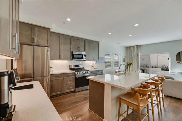 a kitchen with stainless steel appliances a stove a sink a microwave and a refrigerator