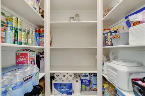 a large kitchen with kitchen island granite countertop a stove a sink a refrigerator and a dining table with wooden floor