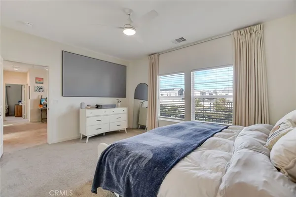 a spacious bedroom with a bed and a chandelier