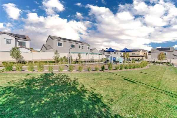a view of a white house with a big yard and large trees