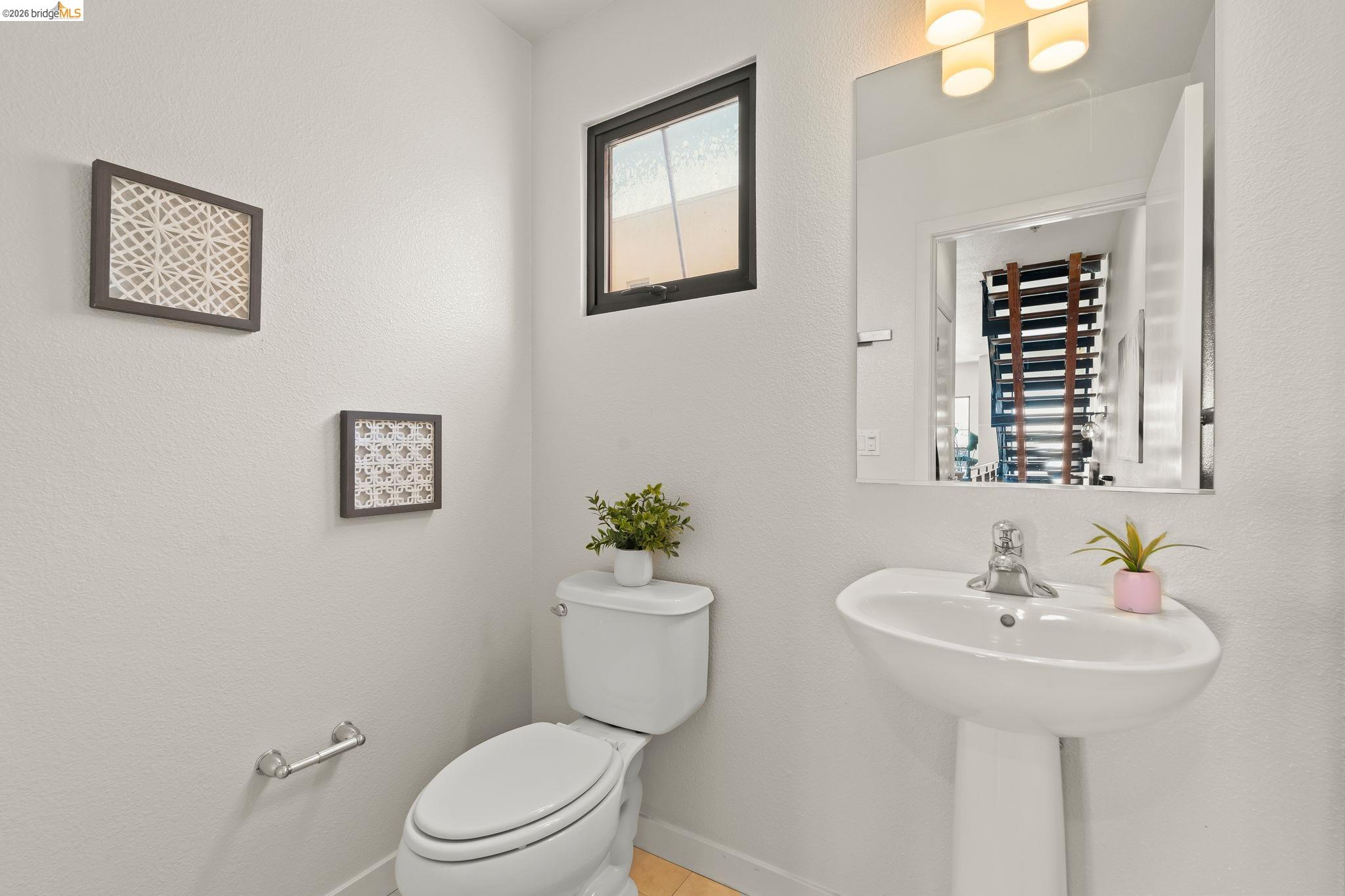1780 12th Street Oakland, CA 94607 - Photo 5 of 31 a bathroom with a toilet a sink and a mirror