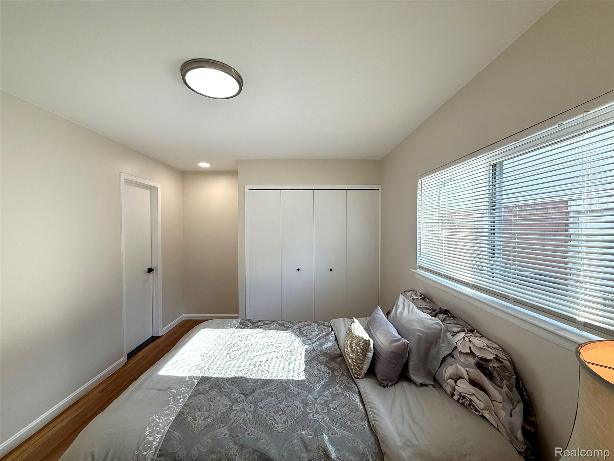 39909 Lynn Street Canton, MI 48187 - Photo 28 of 45 Bedroom featuring wood-finish flooring, a rectangular window with blinds, and white closet doors