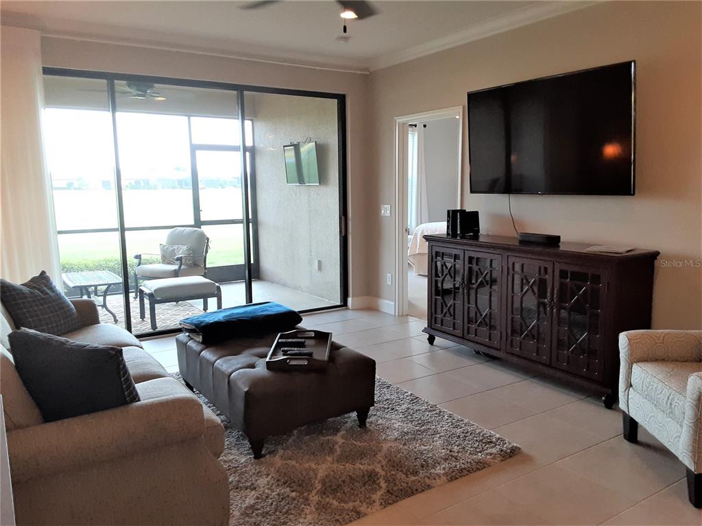 13605 Messina Loop, Unit 104 Bradenton, FL 34211 - Photo 11 of 38 a living room with furniture and a flat screen tv