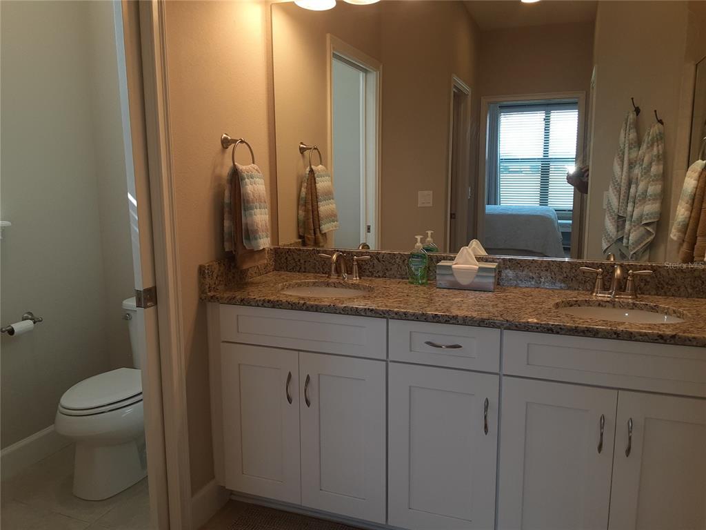 13605 Messina Loop, Unit 104 Bradenton, FL 34211 - Photo 20 of 38 a bathroom with a granite countertop sink and a mirror