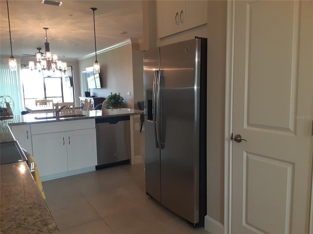 13605 Messina Loop, Unit 104 Bradenton, FL 34211 - Photo 5 of 38 a kitchen with stainless steel appliances granite countertop a refrigerator and a sink