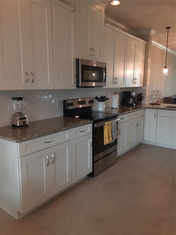 13605 Messina Loop, Unit 104 Bradenton, FL 34211 - Photo 6 of 38 a kitchen with granite countertop white cabinets stainless steel appliances and a sink