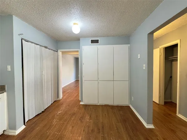 an empty room with wooden floor and closet