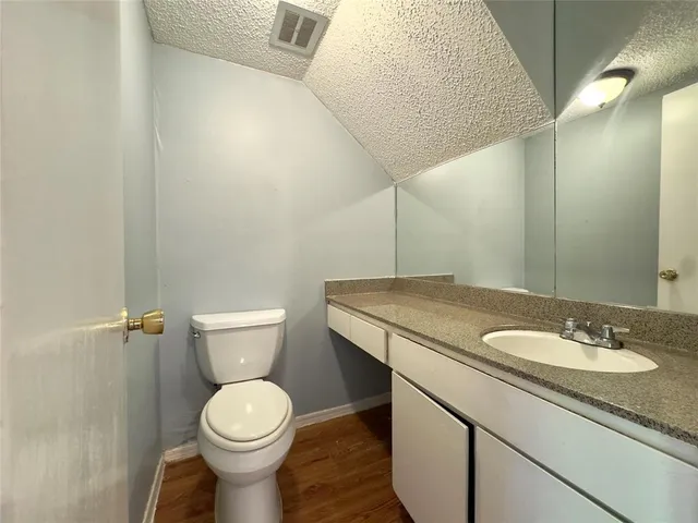 a bathroom with a granite countertop sink toilet and a mirror