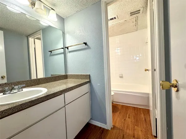 a bathroom with a granite countertop sink toilet and shower