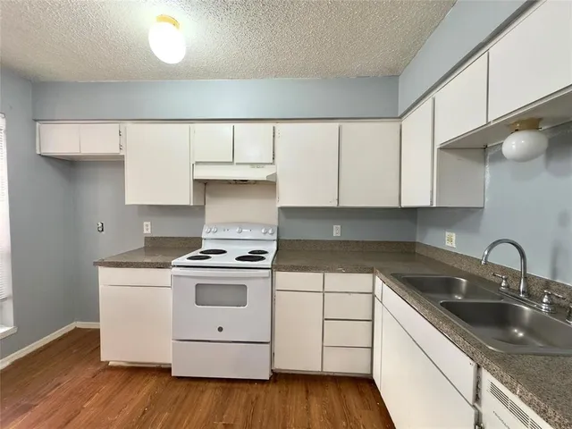 a kitchen with a stove sink and cabinets
