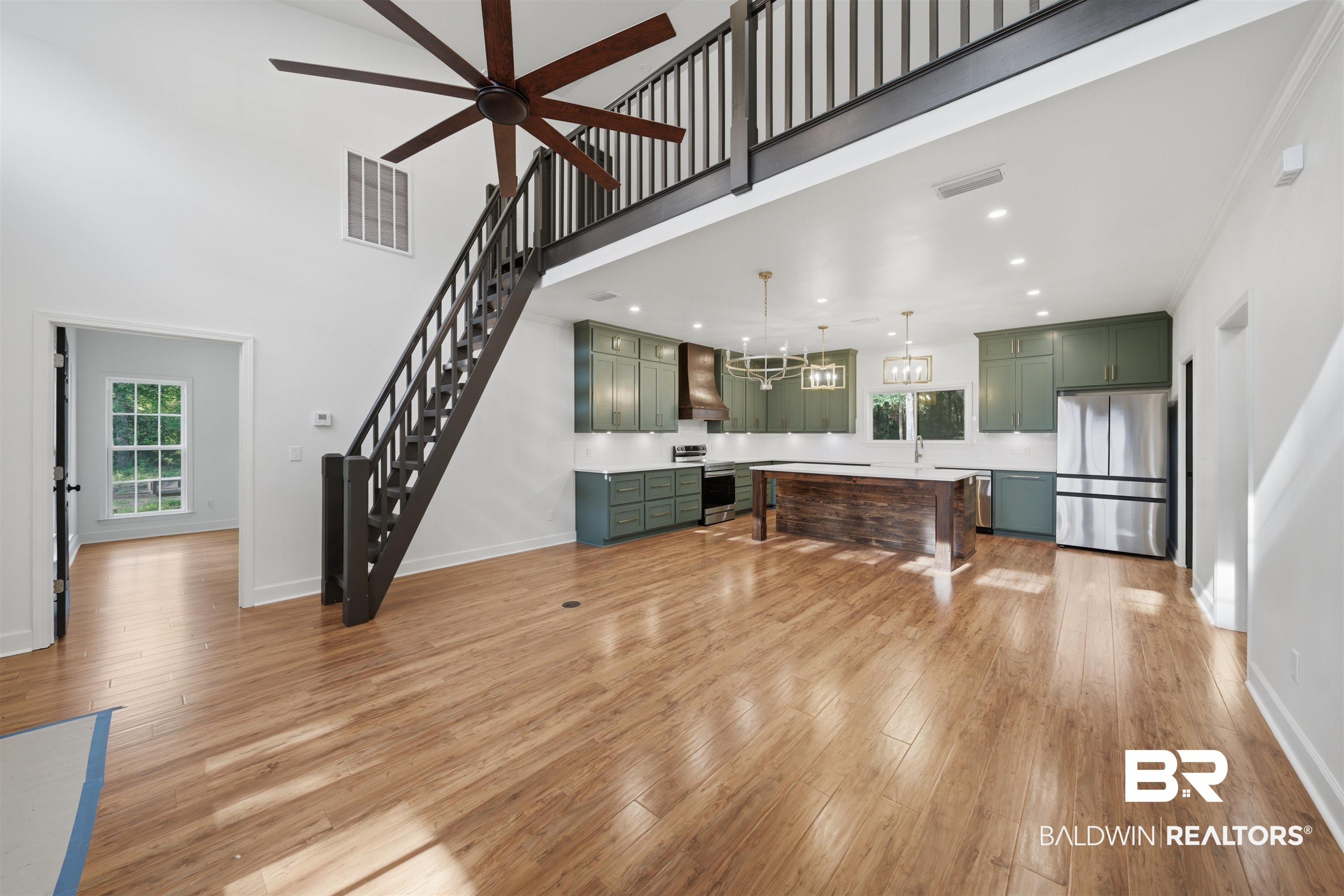 14128 Jackson Lane Foley, AL 36535 - Photo 6 of 36 Expansive open-concept living area featuring a kitchen with green cabinetry, a large wood-finish island, and stainless steel appliances