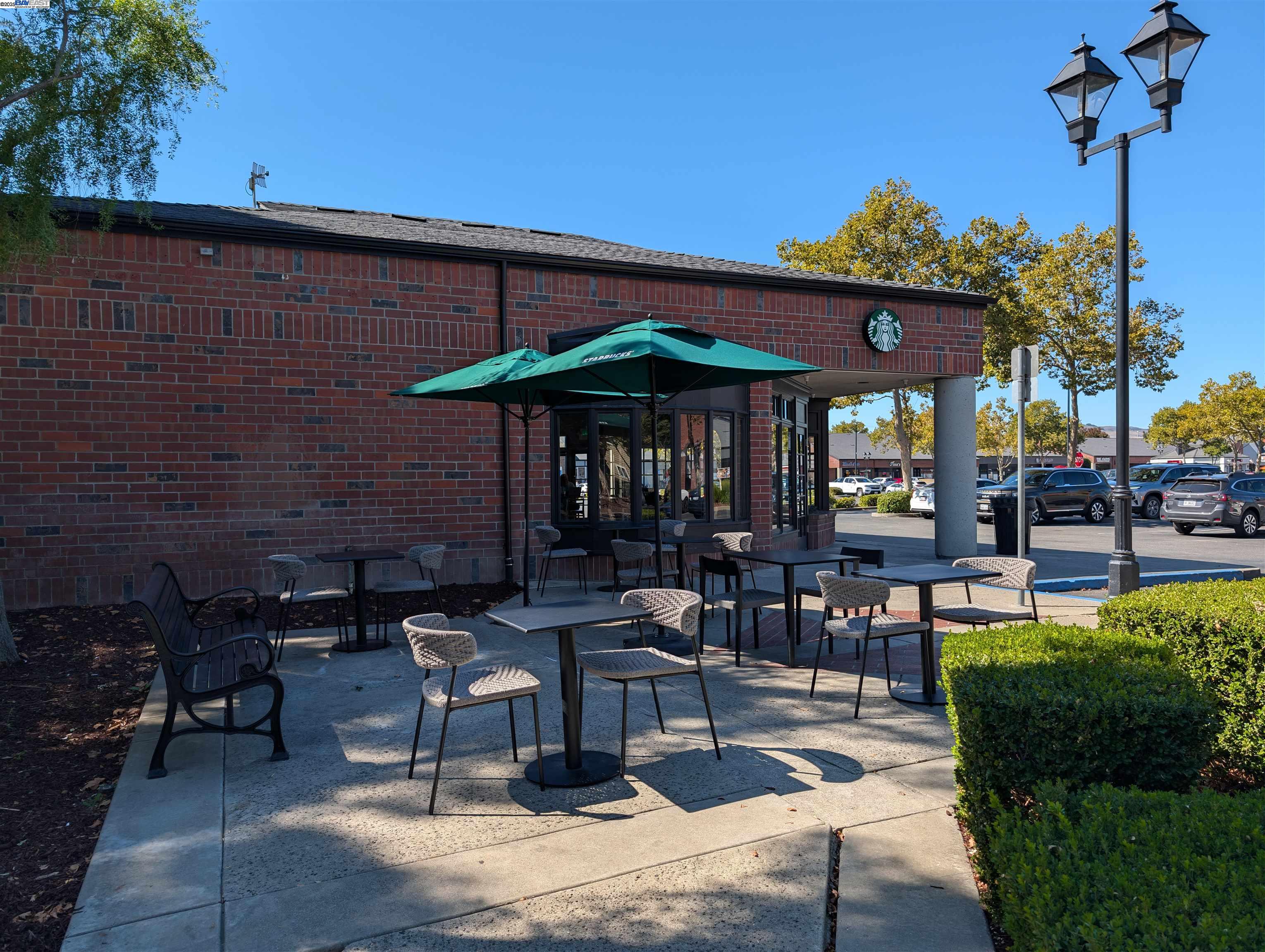 285 Reflections Drive, Unit 23 San Ramon, CA 94583 - Photo 32 of 33 a view of a patio with dining table and chairs under an umbrella with a fire pit