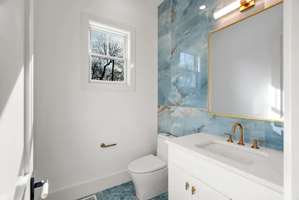 a bathroom with a toilet sink and mirror
