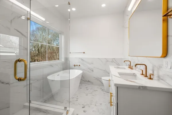 a bathroom with a sink a toilet and shower