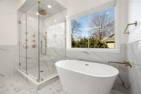 a white bath tub sitting next to a shower