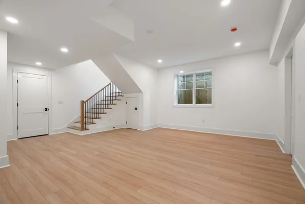 an empty room with wooden floor and stairs