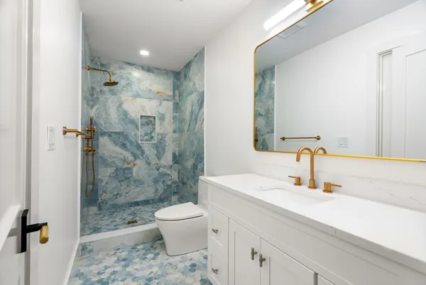 a bathroom with a sink a toilet and shower